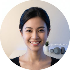 Portrait of a young woman, @minimal_desk, smiling against a warm cream background with subtle blue lighting.