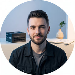 Circular portrait of a young man, @silicon.art, smiling subtly. A 1000W fully modular ATX power supply is in the background.